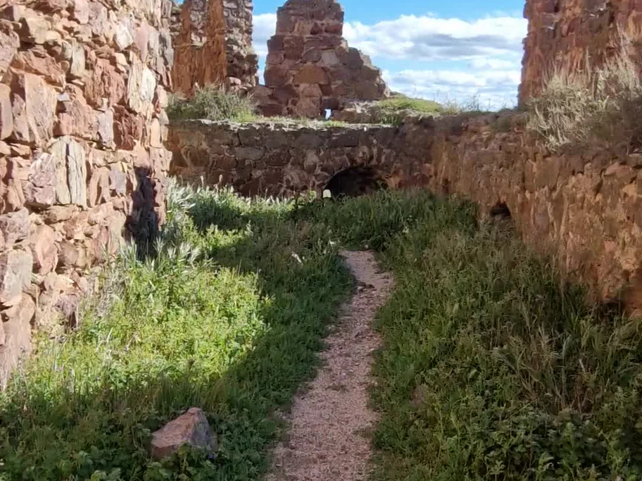 Camino de tierra entre los muros en ruinas del Castillo de Almonacid