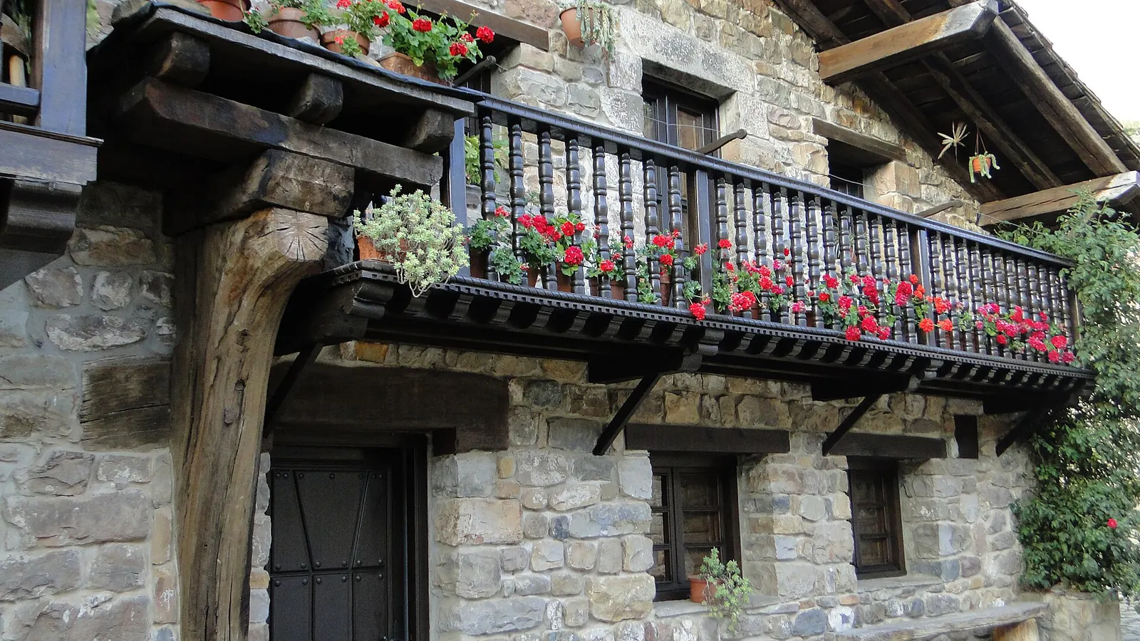 Balcón de madera con flores en Bárcena Mayor