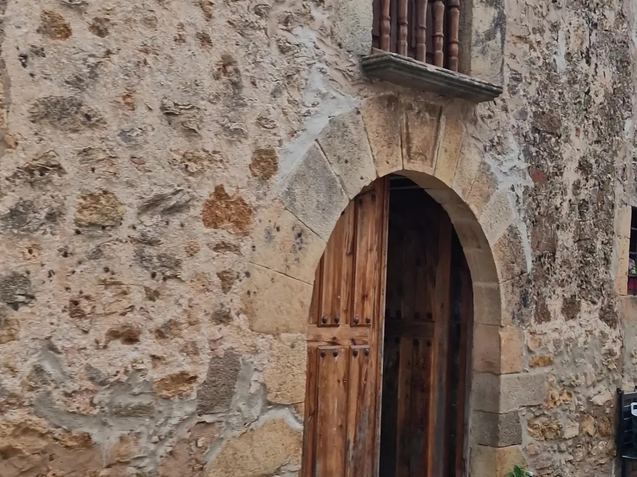 Portada de piedra con puerta de madera en una casa de Calatañazor