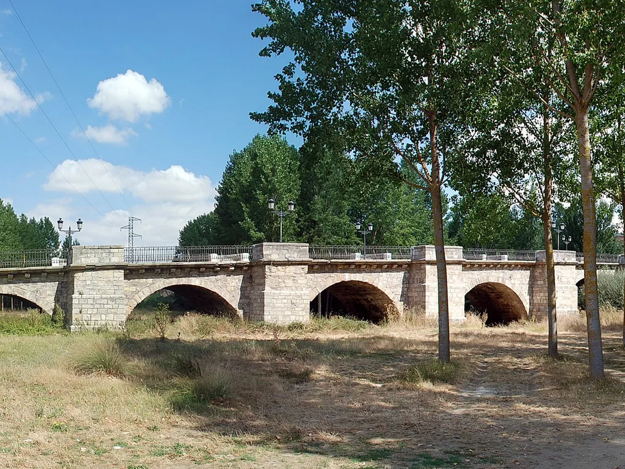 Río Carrión con árboles y puente en Carrión de los Condes