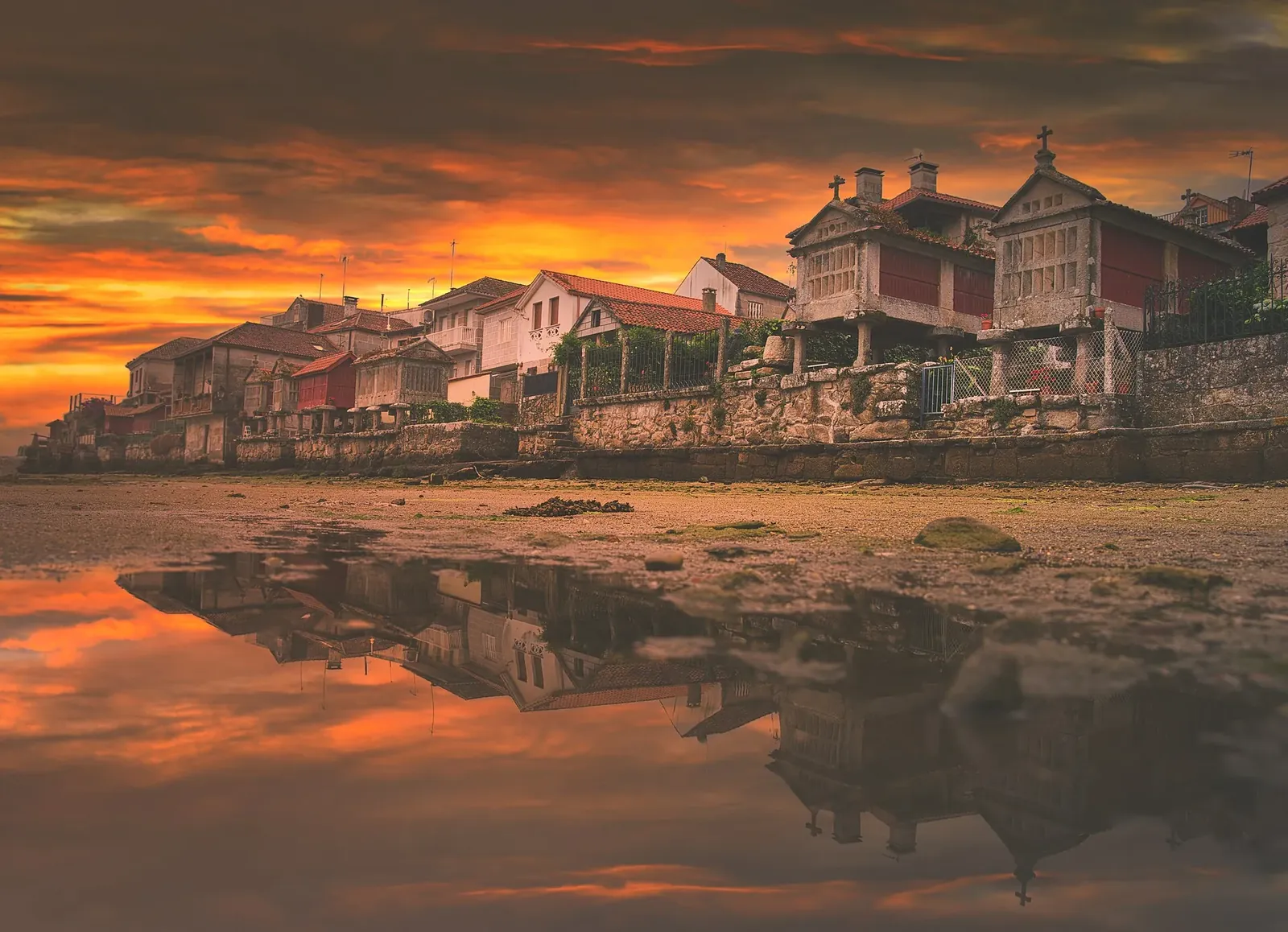 Hórreos de Combarro al atardecer reflejados en el agua