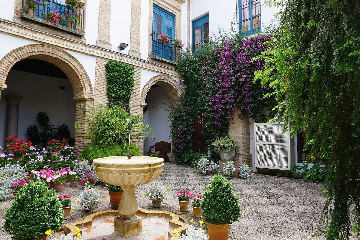 Patio cordobés con fuente y macetas de flores