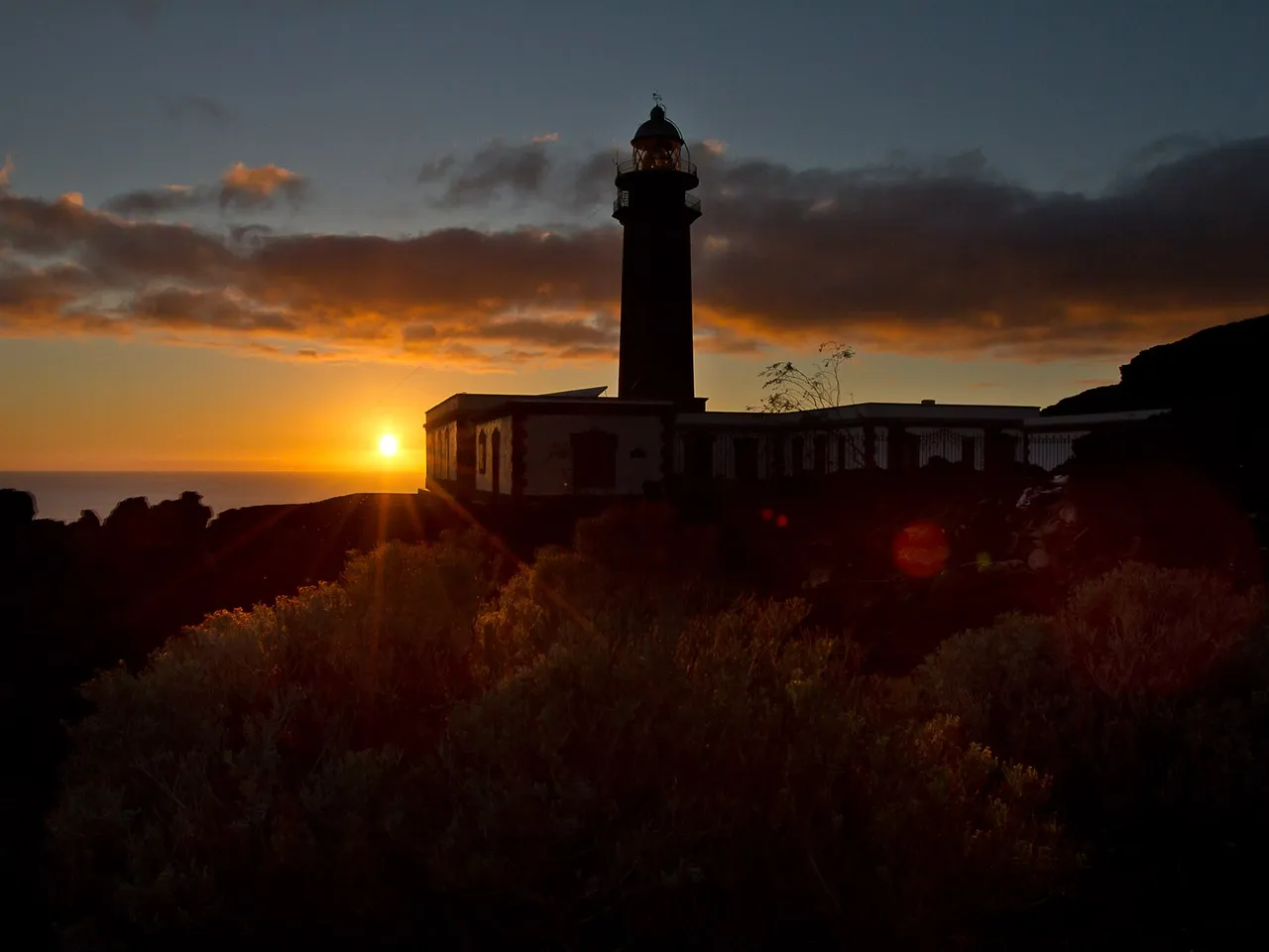 Silueta del Faro de Orchilla con el cielo rojizo del atardecer