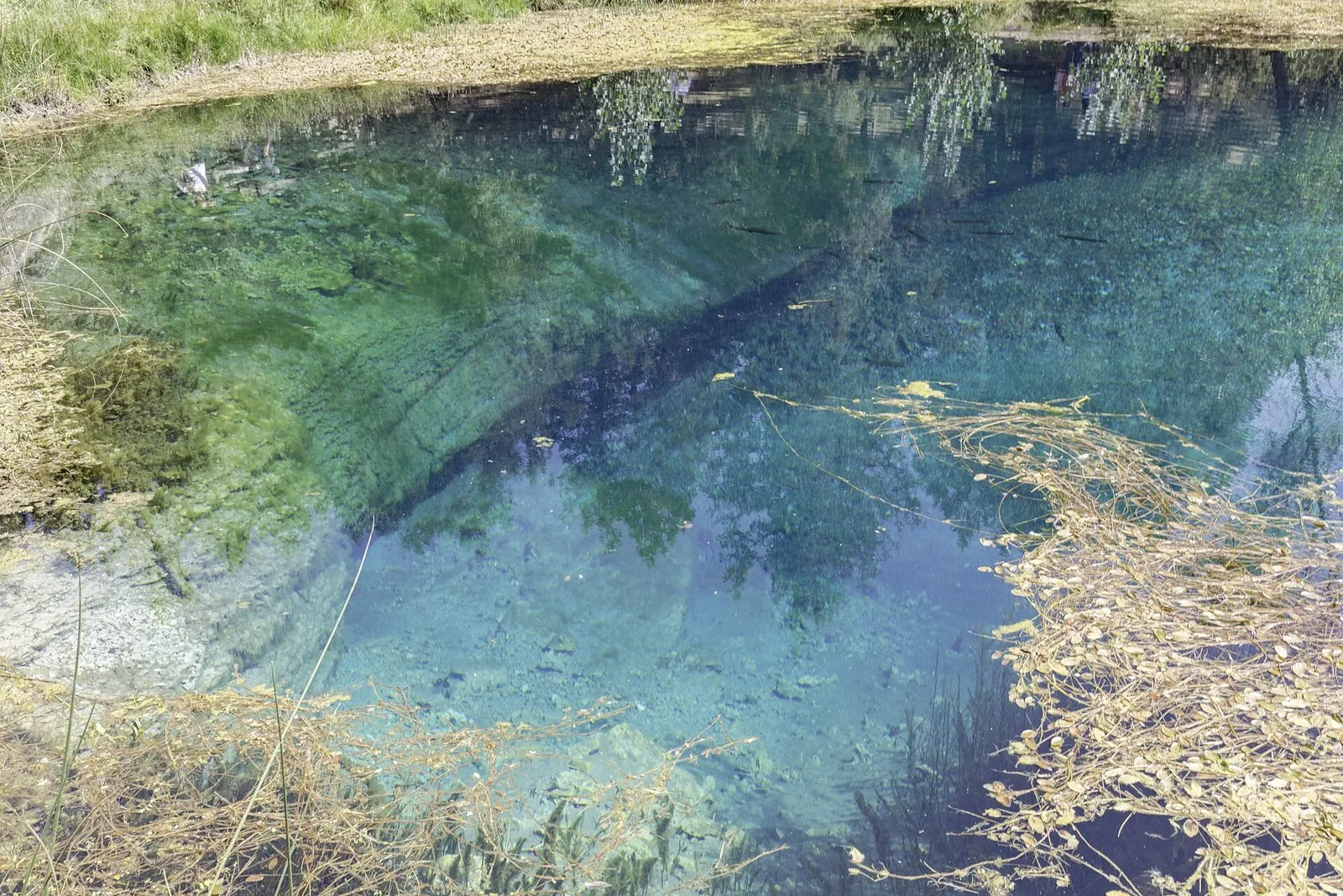 Agua transparente de La Fuentona con el fondo de roca visible