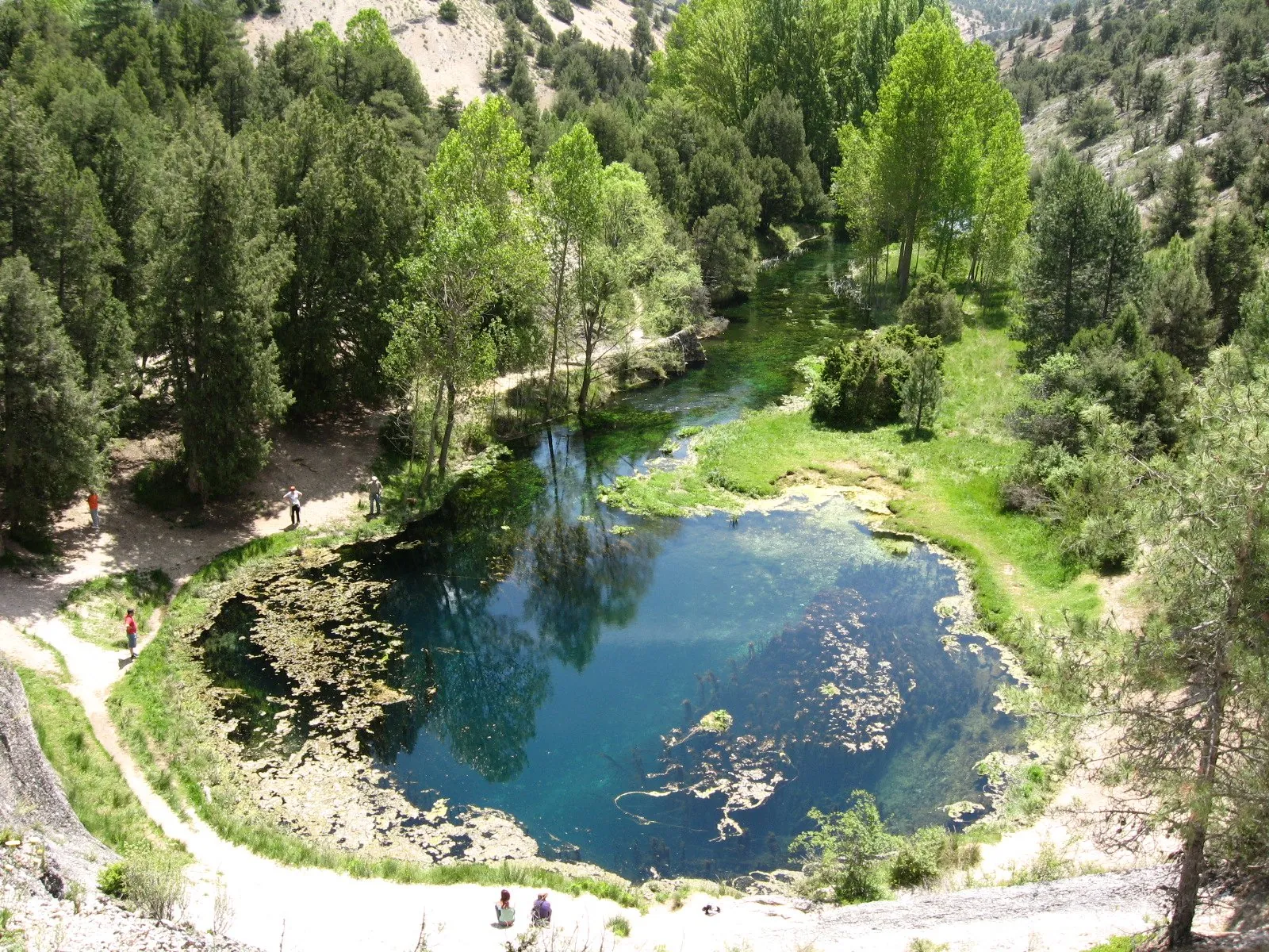 La Fuentona, poza redonda de agua turquesa rodeada de árboles
