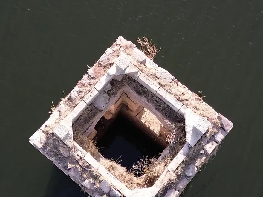 Vista cenital de la torre del campanario de La Muedra con el agua oscura alrededor