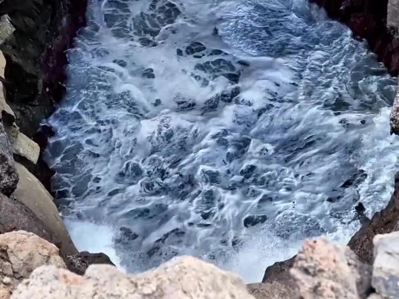 Olas entrando en un hueco de la lava en Los Hervideros