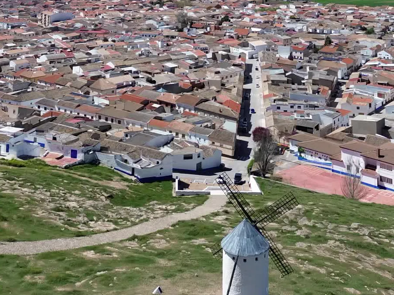 Molino blanco de Campo de Criptana con el pueblo y la llanura detrás
