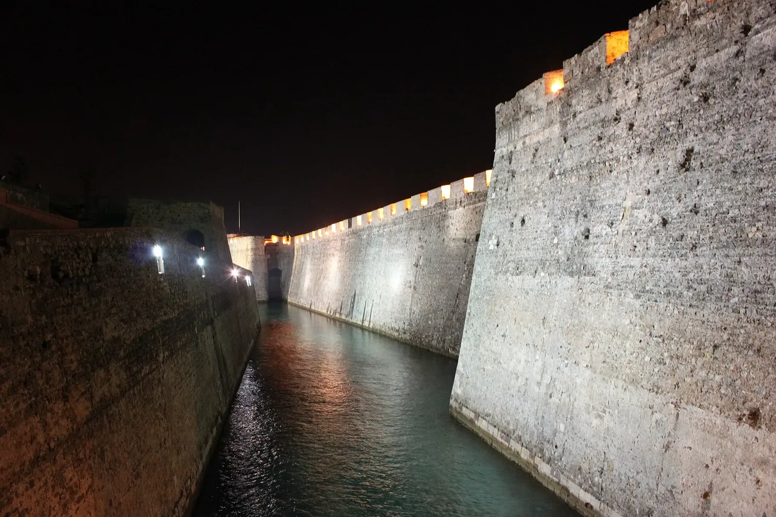 Foso de San Felipe iluminado de noche entre las murallas