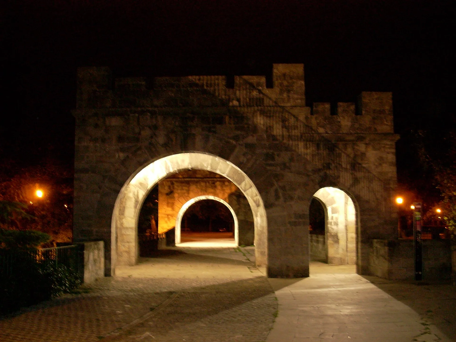 Puerta de la muralla de Pamplona iluminada de noche