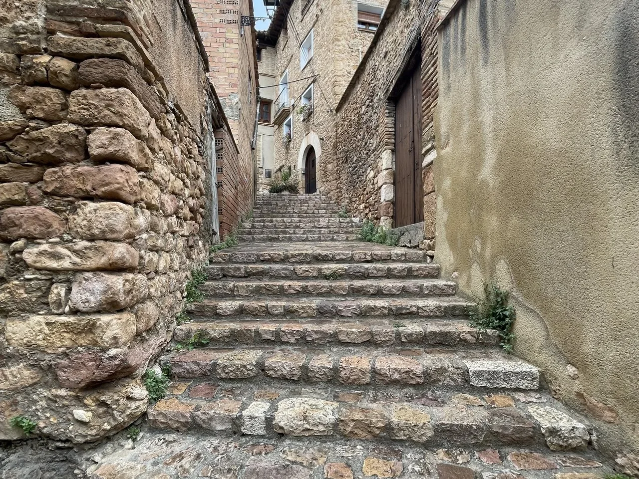 Calle empedrada con escaleras en Alquézar