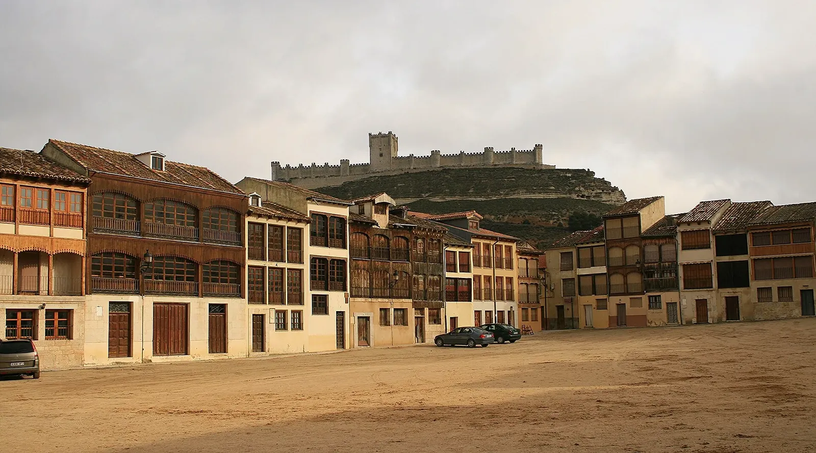 Plaza del Coso de Peñafiel con sus balcones de madera y el castillo al fondo