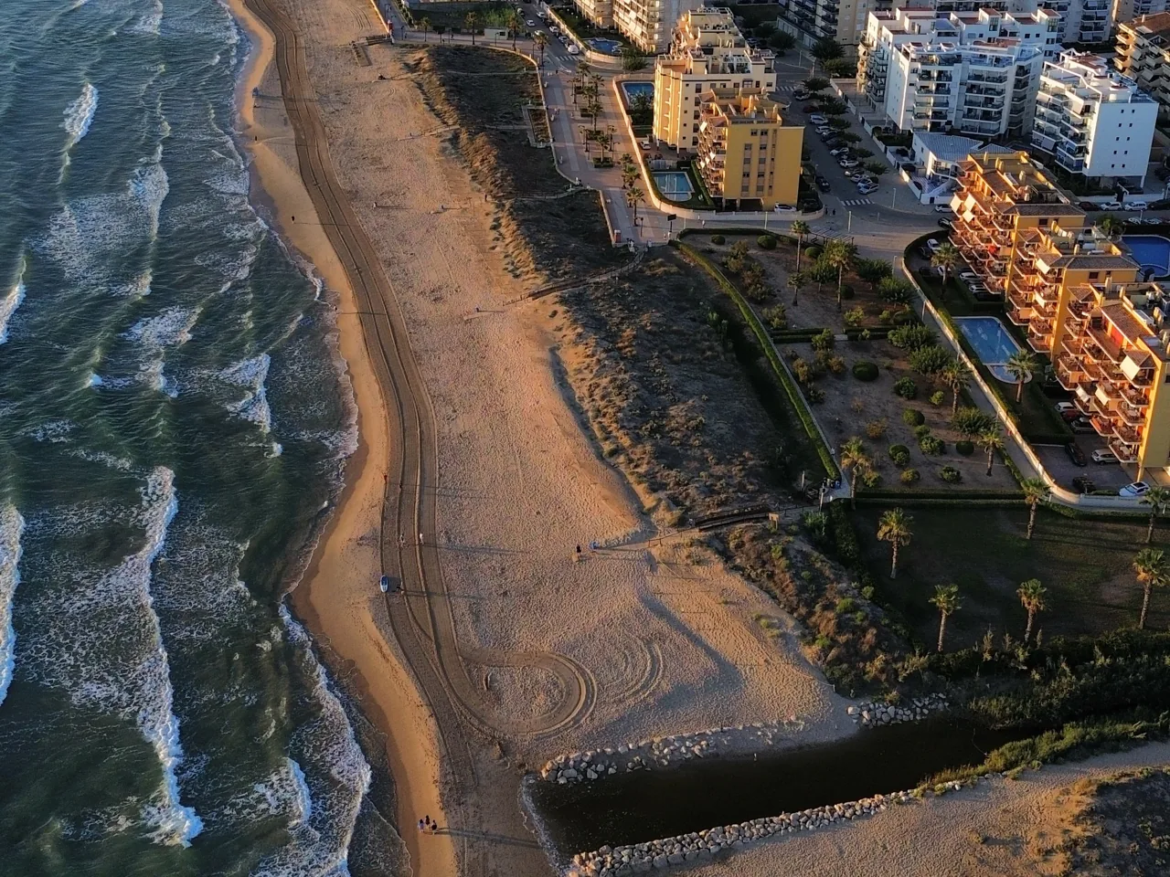 Playa de Daimús con edificios y una piscina junto a las dunas