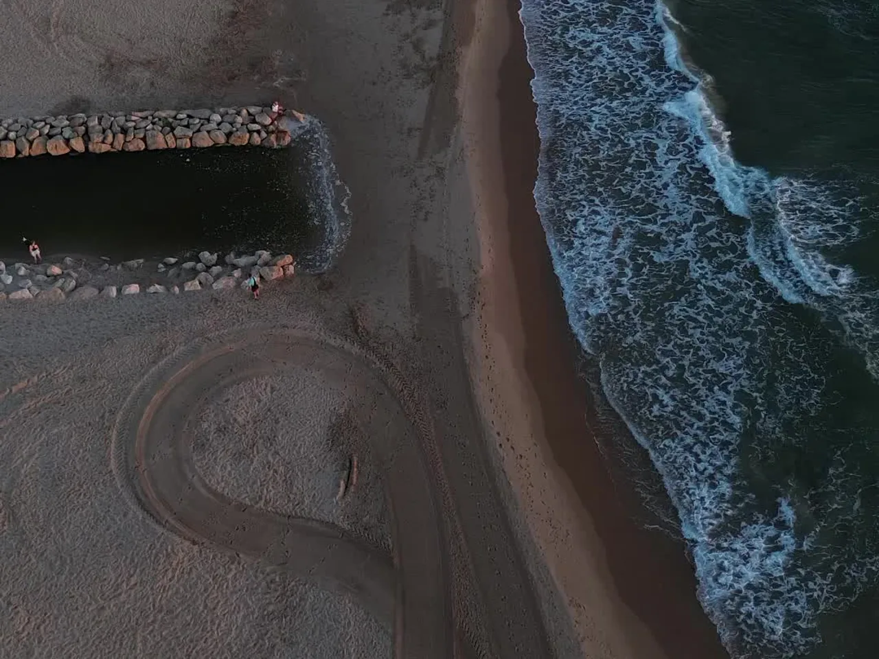 Espigón y huellas en la arena de la playa de Daimús vistos desde arriba