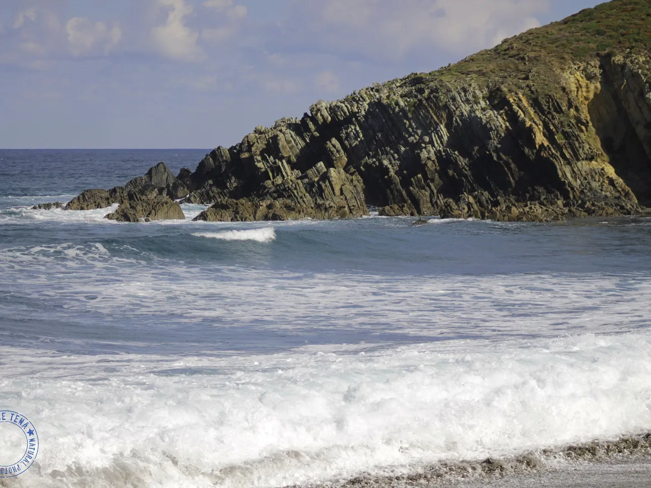 Olas y acantilado en la playa de Frexulfe