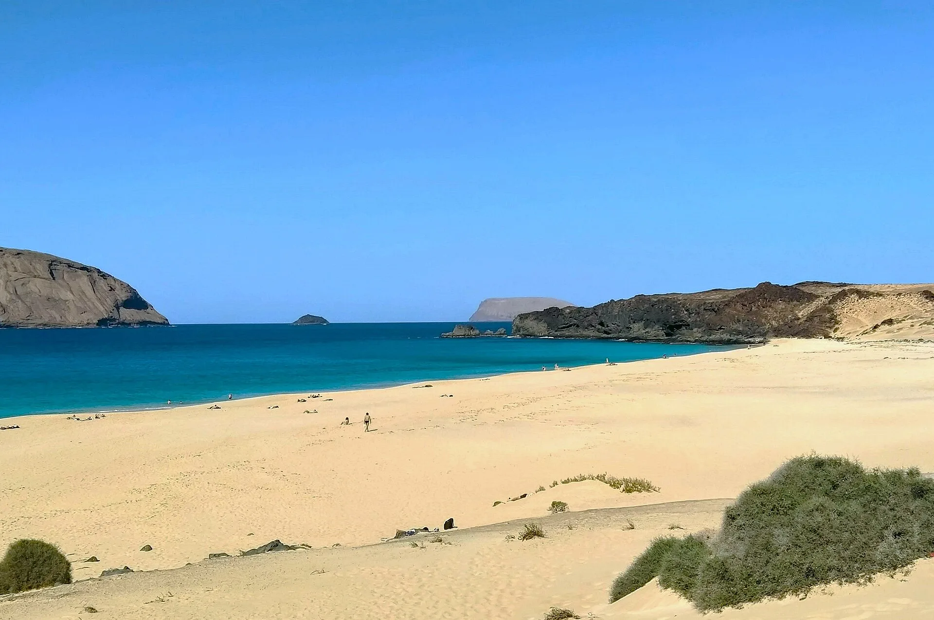 Arena dorada y mar azul en la Playa de las Conchas