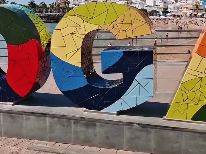 Letras de colores con el nombre de Mogán junto a la playa