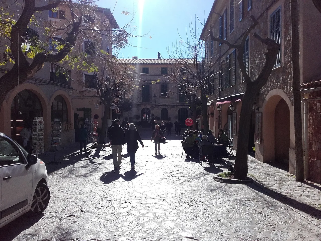 Calle empedrada de Valldemossa con casas de piedra y gente paseando
